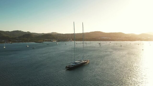 Huge Superyacht in the Caribbean, at golden hour, in Slow Motion. Luxury sailing yacht Aquijo, in Rodney Bay, Saint Lucia. Expensive boat in St.Lucia, evening aerial video in 4K, 60fps slowed to 30fps