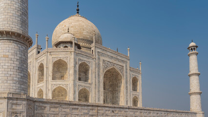 Obraz premium Beautiful Taj Mahal against the blue sky. Symmetrical white marble mausoleum with arches, domes, minarets. There are ornaments on the walls, inlaid with precious stones. Agra. India.