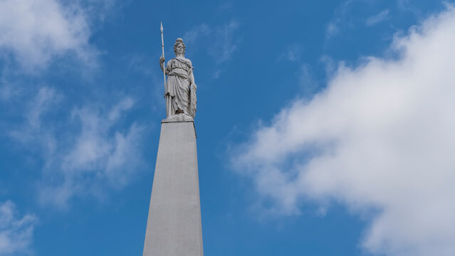 The old patriotic May pyramid-Pirámida de Mayo-in Buenos Aires against a background of blue sky and clouds. A white stone stele with a statue of a woman with a spear on top. It was built in 1811.