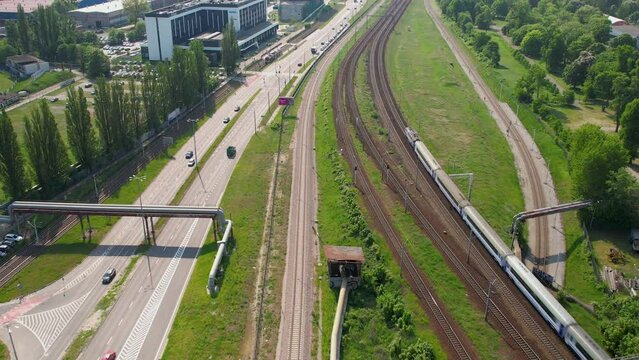 Aerial birds eye flight over highway with traffic and train in Gdansk during sunny day, Poland - Establishing aerial shot