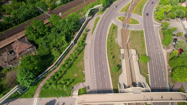 Aerial tilt up shot of highway, rails and cityscape of Gdansk in background during sunny day,Poland - Establishing shot