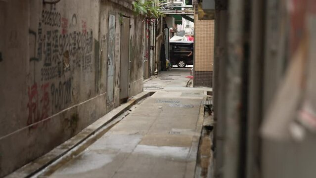 Long shot of two asian women walking down empty alleyway in Hong Kong, China