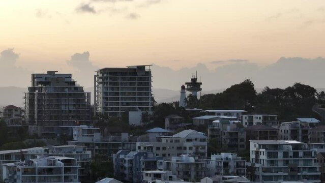 Drone Flyover Luxury Oceanfront Apartments And Lighthouse At Sunset, Telephoto Parallax Australia