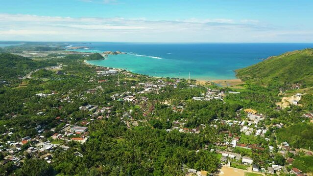 Aerial over the beach resort town of Kuta or Mandalika, Lombok Island, Indonesia. Drone slow dolly forward shot