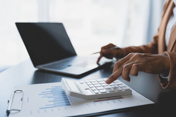 Businesswoman using calculator to check company finances income and budget Calculate monthly expenses, manage budgets, financial reports, invoices, graph documents. data chart startup business ideas