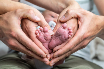 sweet newborn family forming Baby feet heart baby's feet in mom and dad parent hands selective color - 616013858
