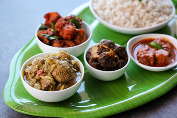 Kerala special food sadhya in banana leaf plate with Chicken fry Duck roast Beef fry Fish curry Cabbage thoran. Festival food for Christmas Easter celebration Kerala India Sri Lanka 