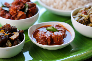 Kerala special food sadhya in banana leaf plate with Chicken fry Duck roast Beef fry Fish curry Cabbage thoran. Festival food for Christmas Easter celebration Kerala India Sri Lanka 