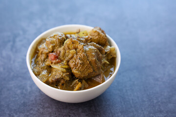 A traditional duck curry roast. Kerala style duck or chicken curry with coconut milk for appam rice. Indian food in black background. 