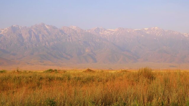 Central Tien Shan. Foothills. Wild Nature. Wall of mountains in the background, steppe in the foreground. Golden hour photography