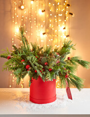 Floral arrangement in a round red box with a live spruce for decorating the house for the Christmas holidays. Christmas wooden box with fir branches for the holiday. The new year celebration. European