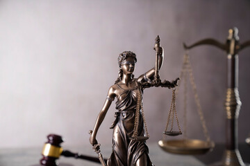 Law symbols composition. Gavel, scale and Themis sculpture on the gray background.