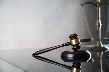 Law symbols composition. Gavel, scale and Themis sculpture on the gray background.