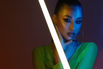 beautiful young woman with neon lamp. Pretty girl in color lights