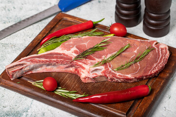 Raw veal chops. Fresh veal rib boned raw chops on wood serving board
