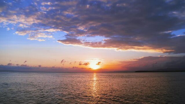 Bright sunset over the ocean. Orange sky with glow in the clouds. Sea waves with sun reflection. Breathtaking sunset over the sea.Calm morning seascape. Evening sky for meditation. Horizon over water.