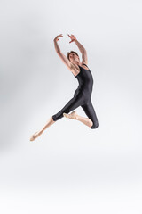 Professional Ballet Dancer Young Caucasian Athletic Man in Black Suit Posing Dancing in Studio On White.