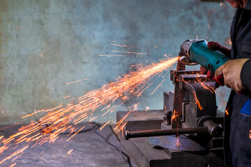 Metal Processing. Man Fitter in Protective Gloves and Uniform With Gringer Tool For Metal Work With Bunch of Sparks