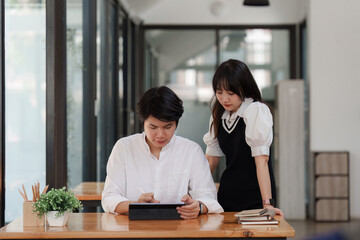 Young entrepreneur couple working on a tablet at cafe. Small business management concept