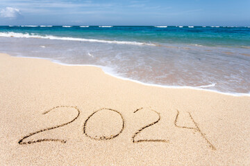 New Year 2024, lettering on the beach with wave