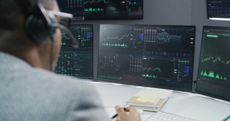 African American stock trader communicates with investment adviser about real-time stocks and exchange market charts on computer. Businesspeople work in broker agency office. Investment and analytics.