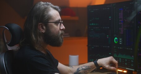 Fototapeta na wymiar Male trader analyzes real-time stocks, exchange market charts on multi-monitor computer workstation, eats french fries. Man works in investment at home office in the evening. Cryptocurrency trading.
