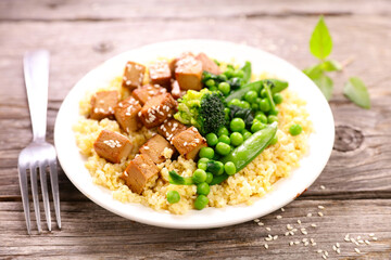 plate with fried tofu, bulgur and green vegetables- vegan lunch or dinner