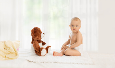 Cute baby playing with teddy bear