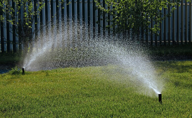 Automatic garden irrigation system watering lawn with adjustable head. Automatic equipment for...