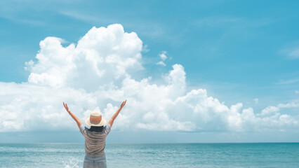 Young woman rise hand up to sky feel relax and free with summer beach background.