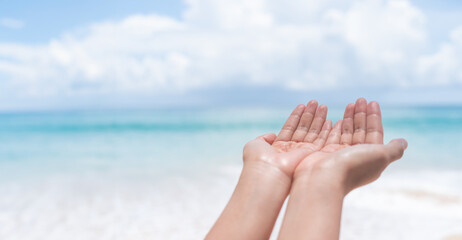 Hands do pray position on nature summer beach and blue sky background.