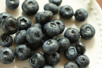 白い皿に盛られた新鮮なブルーベリーのクローズアップ