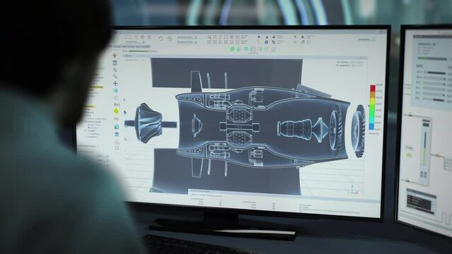 An Engineer using futuristic software to construct a gas turbine prototype. Engineer building a machine prototype in computer software. Engineer inspecting the prototype schematic in desktop software.