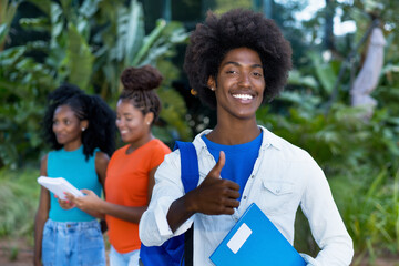 Successful and happy african american male student with group of black young adults