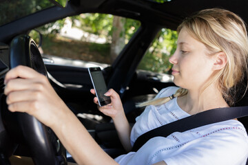 Fototapeta na wymiar young woman texting while driving her car
