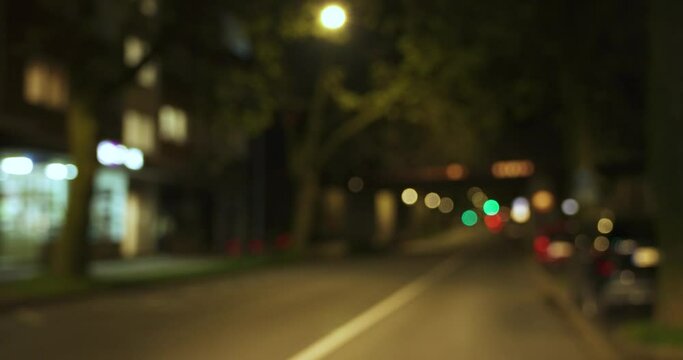 Blick durch die Frontscheibe eines Autos, das nachts durch die Stadt f&auml;hrt