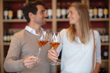couple clinking glasses in wine shop