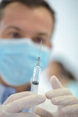 mans hand in medical glove with syringe