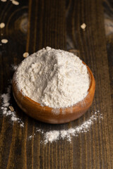 Fototapeta na wymiar Wheat flour from a wooden bowl