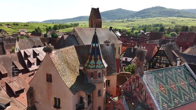 Aerial Drone Shot of Eguisheim village in the Alsace province, France. Picturesque Church with storks at Sunny Day