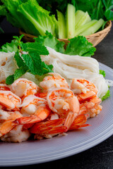 Close up of steam shrimp and pork belly with fresh vegetable on table.