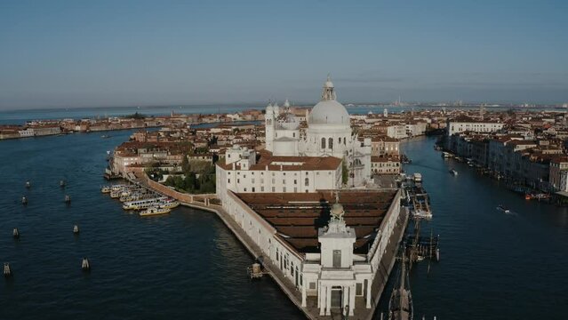 Aerial view flying over Punta della Dogana and Basilica di Santa Maria della Salute in Venice, Italy.