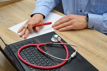 Weterynarz siedzący przy biurku wypisuje zalecenia dla pacjentów 