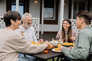 family bbq party, celebration of parents day, cheerful teenage girl sitting next to adult brother, sitting on backyard of summer house, spending time together, eating grilled bbq food