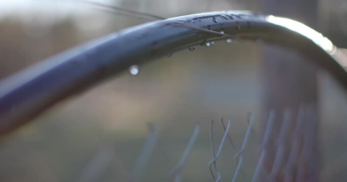 Close up of fence with waterdrops on agricultural field at countryside on sunny day, slow motion