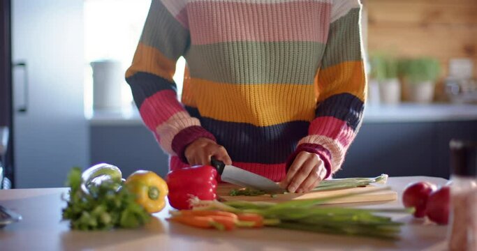 African american woman chopping vegetables in sunny kitchen