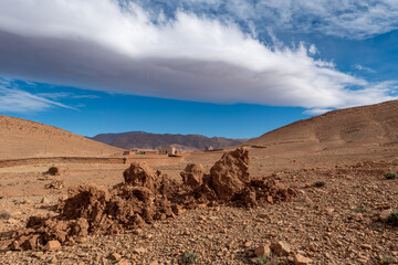 Berbersiedlung in steiniger Berglandschaft mit blauem Himmel und Wolken