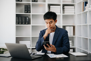 Asian business man executive manager looking at laptop watching online webinar training or having virtual meeting video conference doing market research working .