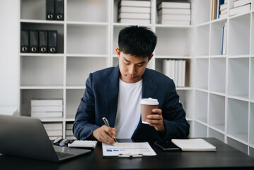 Asian business man executive manager looking at laptop watching online webinar training or having virtual meeting video conference doing market research working .