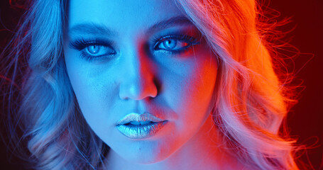 Fairy. Caucasian woman's portrait isolated on blue studio background in multicolored neon light. Beautiful female model. Concept of human emotions, facial expression, sales, ad, fashion. Copyspace.
